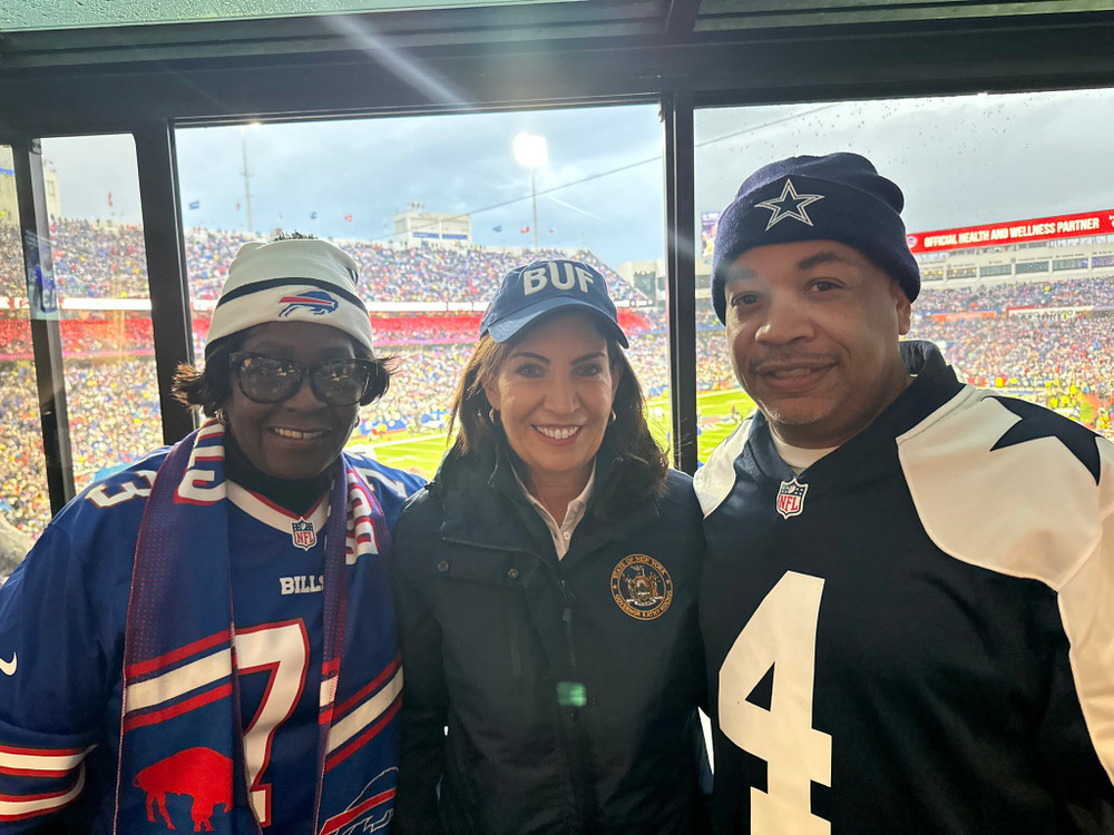 Assembly Majority Leader Crystal Peoples-Stokes and Governor Kathy Hochul, wearing Buffalo Bills gear, and Assembly Speaker Carl Heastie, wearing Dallas Cowboys gear, at the Buffalo Bills game on December 17, 2023.