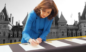 Photo collage of Governor Kathy Hochul signing papers in front of the Capitol Building in Albany.