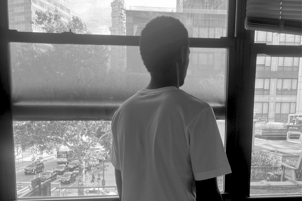 Theirno sits at a table, looking over his shoulder out of the window.