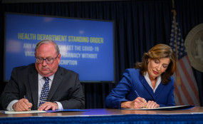 Governor Kathy Hochul and her health department commissioner James McDonald at a desk