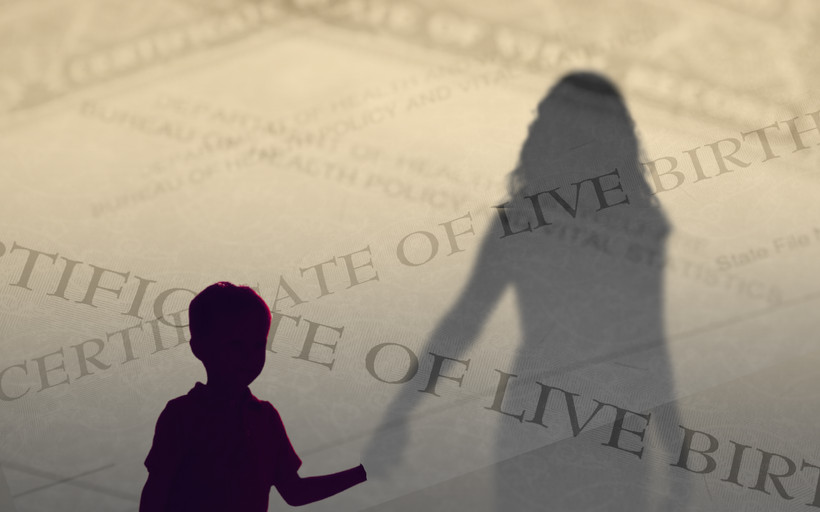 A child silhouetted in the foreground holds hands with an adult, who is separated from the child by a transparent layer composed of birth certificate paperwork.