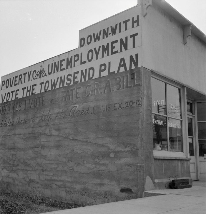 Side of a building reads, "Down with poverty, crime, unemployment; vote the Townsend Plan"