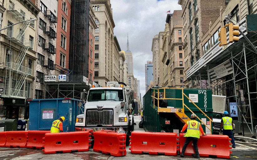 Workers set up barriers on a street in New York City.