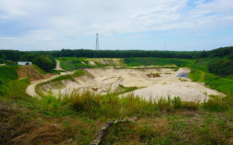 A sand pit among tall green grasses