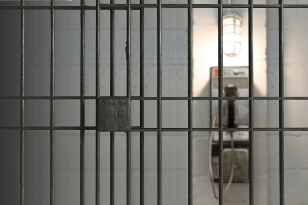 An unreachable phone seen from inside a jail cell.