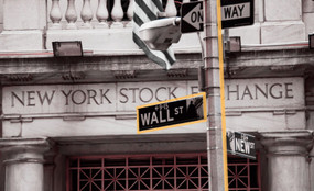 A photo illustration showing the New York Stock Exchange building and the street sign for Wall Street.