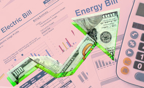 An upwards-pointing arrow made of a hundred-dollar bill, against a background of an energy bill.