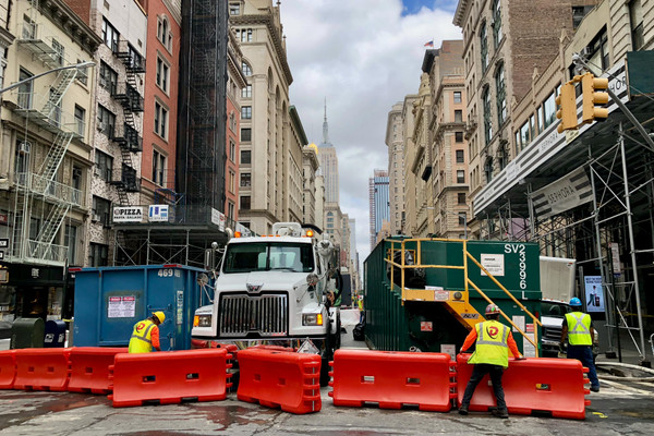 Workers set up barriers on a street in New York City.