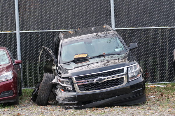 A car with the right side destroyed sits in a lot.