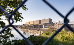 The Gowanus Generating Station in Brooklyn seen through a chain-link fence