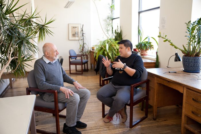 Former In These Times Editor & Publisher Joel Bleifuss having a conversation with incoming Executive Director Alex Han.
