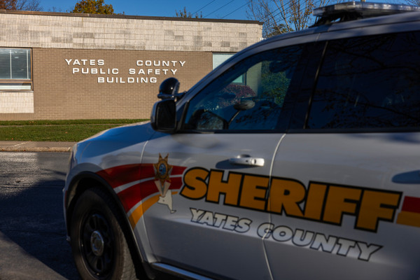 A photograph of a Yates County Sheriff car parked in front of the Yates County Public Safety Building.