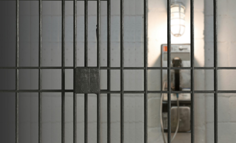 An unreachable phone seen from inside a jail cell.