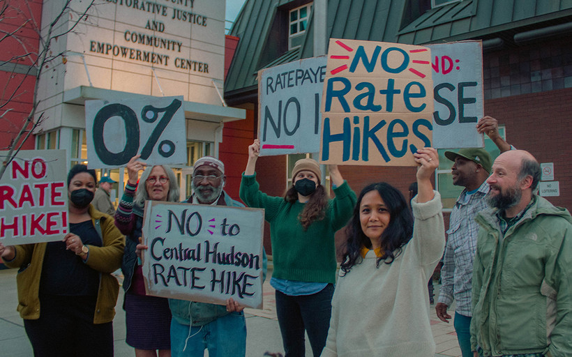 A group of people with signed saying "no rate hikes"
