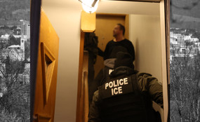 In the foreground, two ICE officers enter a person's warmly-lit home. In the background, black and white image of Ithaca from afar.