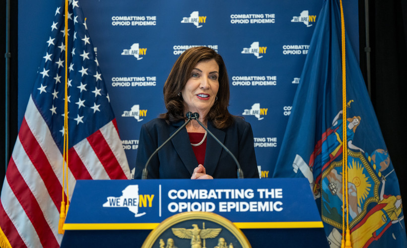 New York City Governor Kathy Hochul stands behind a podium reading "Combatting the Opioid Epidemic"