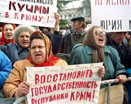 Protesters shouting, holding signs written in Russian