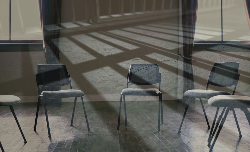 Empty chairs in a circle with the shadows of jail bars over it.