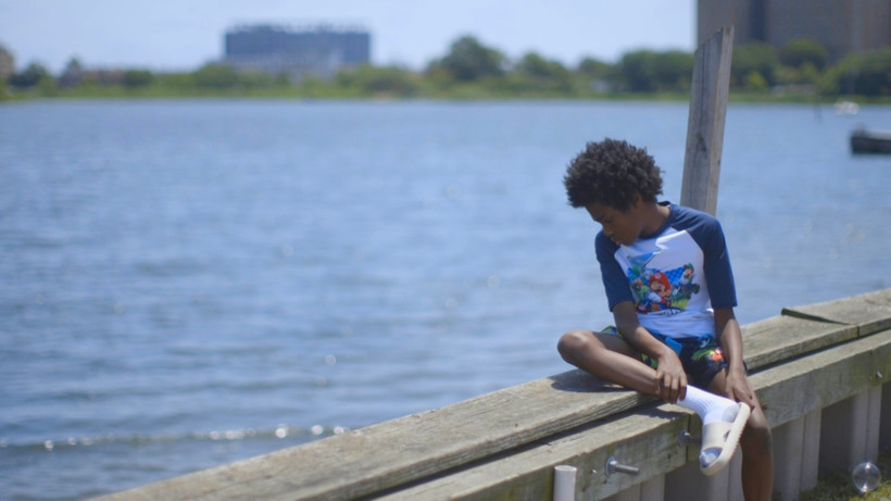 A boy looks out over Jamaica Bay in the Edgemere neighborhood of New York City. The community, which is flanked by the Atlantic Ocean and the bay, is at growing risk of coastal flooding due to sea level rise.