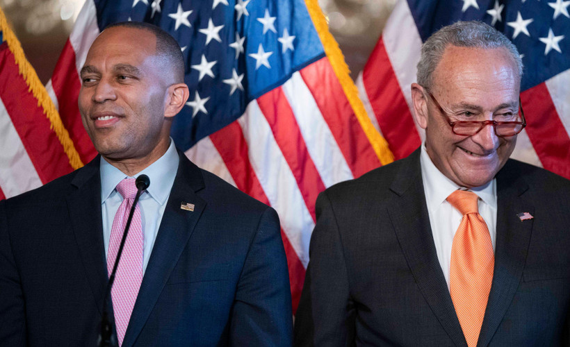 House Minority Leader Hakeem Jeffries and Senate Majority Leader Chuck Schumer, Democrats of New York, smile in front of american flags