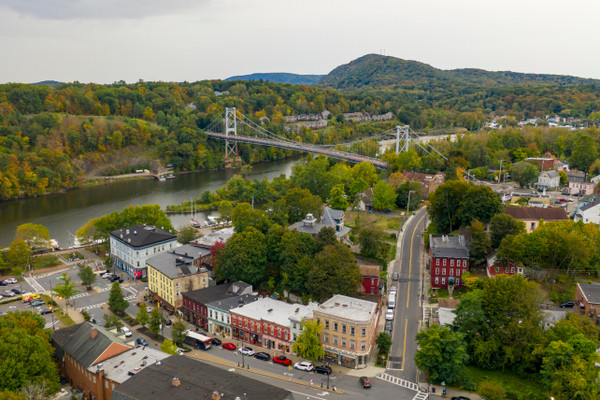 An overhead view shows streets, buildings, trees, and a river in the forested town of Kingston, New York, the Ulster County seat.