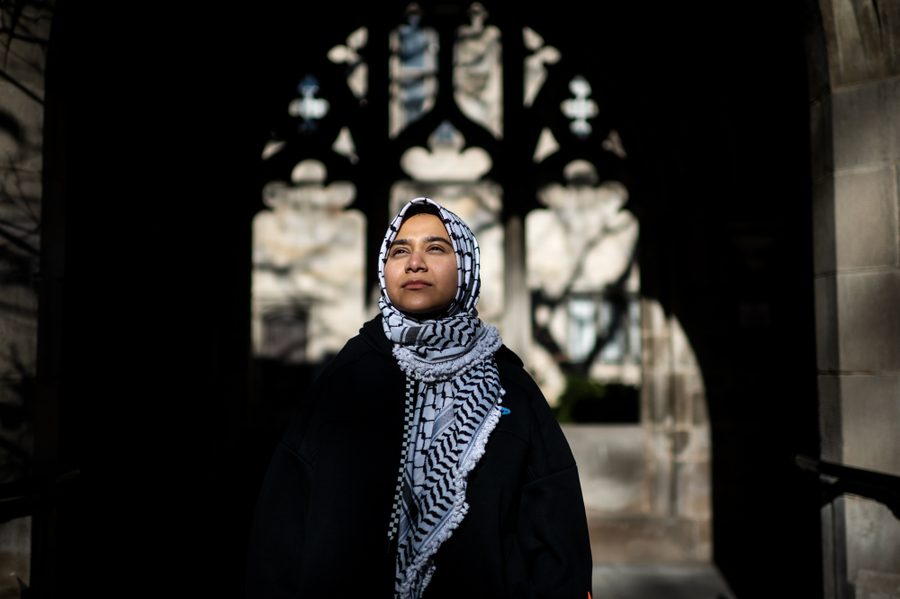 A woman wearing a keffiyeh as a hijab looks ahead.