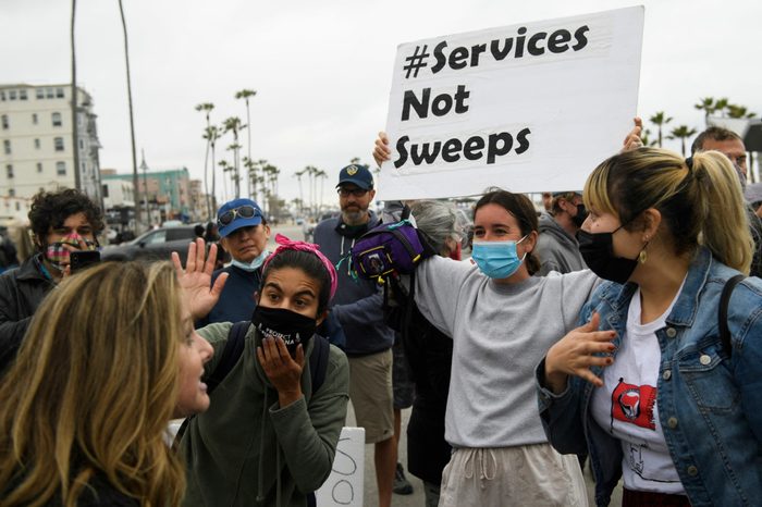 activists are outside in Los Angeles, and look to be having a confrontation with one person. Many activists are wearing face masks to protect from covid.