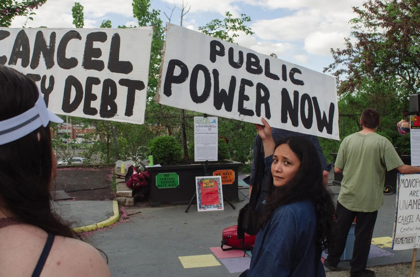 Sarahana Shrestha holding a sign that says "Public Power Now"