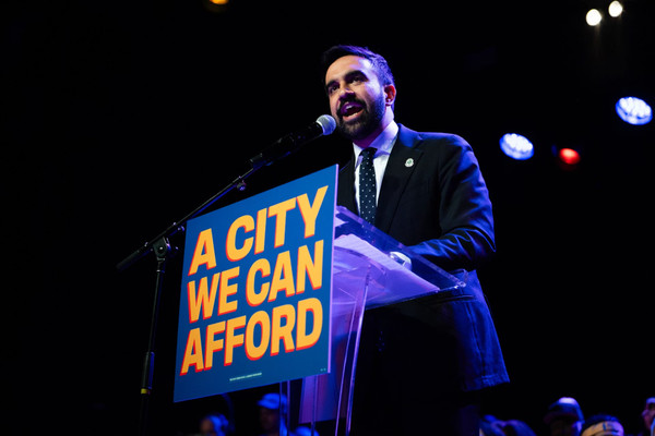 Zohran Mamdani speaking at a podium