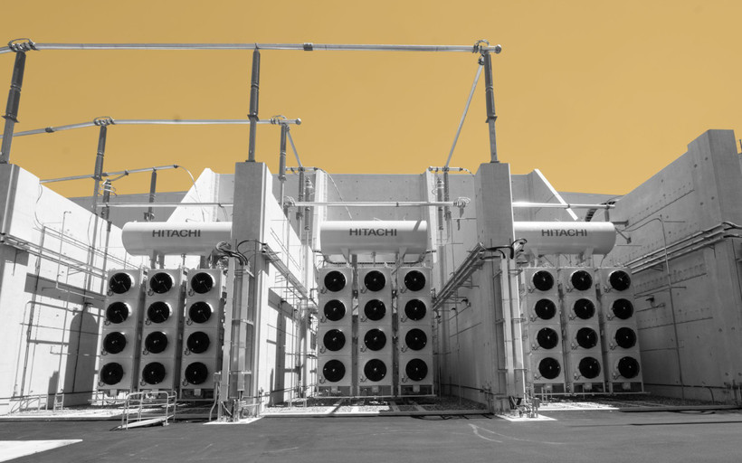 A photo of part of the Camplain Hudson Power Express Converter station, a towering white structure featuring three blocks of twelve fans each.