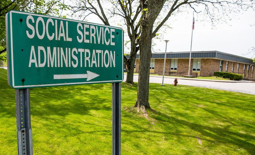 Photograph of a green sign saying "Social Service Administration"