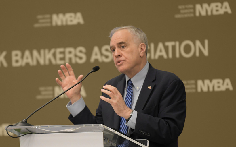 Comptroller Tom DiNapoli speaks at a podium, gesticulating with his hands.