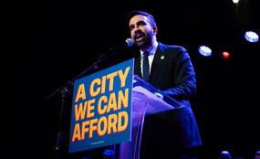 Zohran Mamdani speaking at a podium
