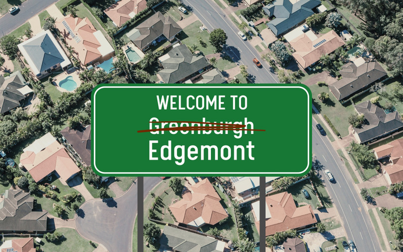 A green welcome sign superimposed over an aerial suburban shot reads "WELCOME TO Greenburgh," with Greenburgh crossed out, and replaced with "Edgemont."