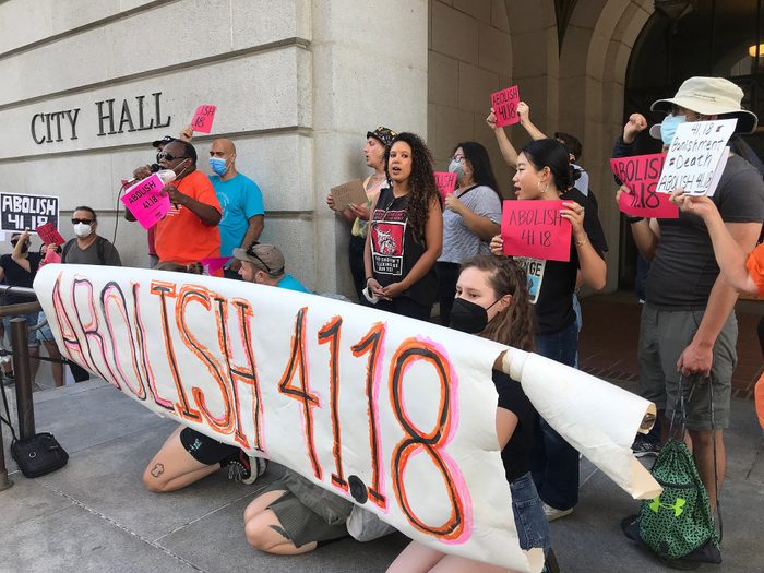 People protesting, holding signs and a banner that says "abolish 41.18"