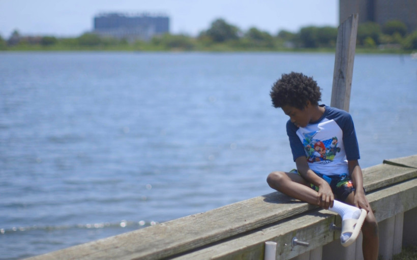 A boy looks out over Jamaica Bay in the Edgemere neighborhood of New York City. The community, which is flanked by the Atlantic Ocean and the bay, is at growing risk of coastal flooding due to sea level rise.