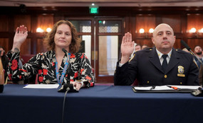 Two city officials at a council hearing