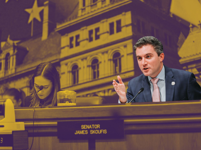 New York Senator James Skoufis is shown sitting down and speaking into a microphone during a legislative hearing.