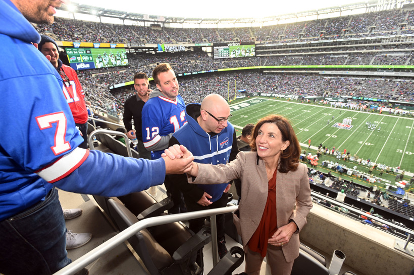 New York Governor Kathy Hochul shakes hands with someone in a Buffalo Bills uniform at Metlife Stadium in New Jersey.