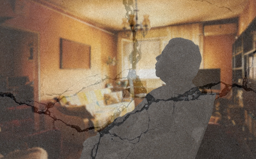 A silhouette of an elderly person sitting alone in a chair in a warm living room. Cracks appear over the image, indicating precarity.