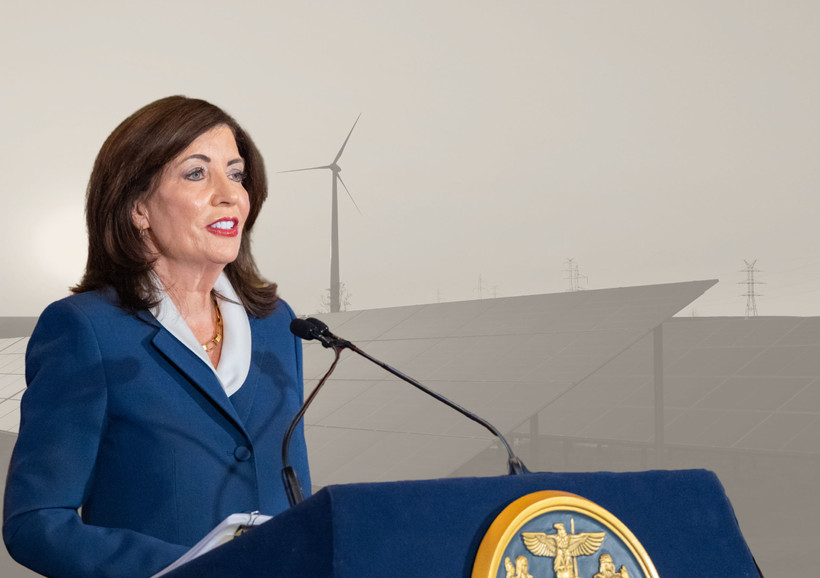 Photo montage showing NY Governor Kathy Hochul speaking on April 28 against a greyed-out backdrop of solar panels and a wind turbine.