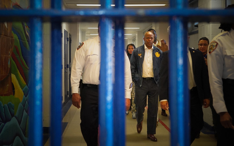 Eric Adams seen through bars at Rikers Island