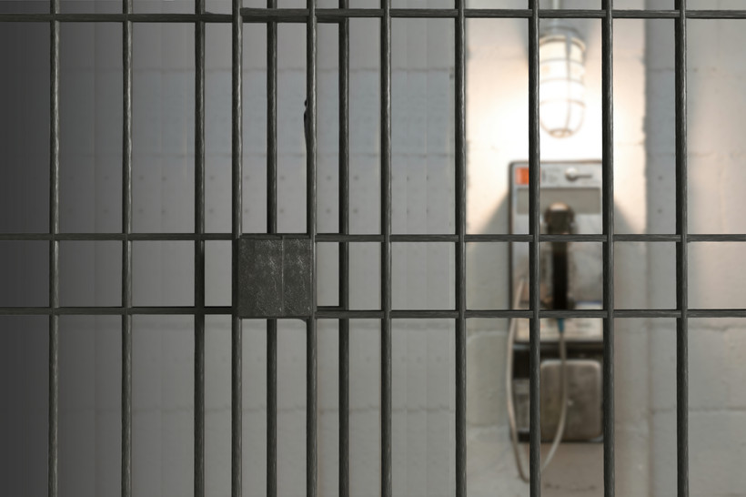 An unreachable phone seen from inside a jail cell.
