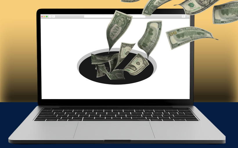 A website on an open laptop sucks in cash via a black hole.