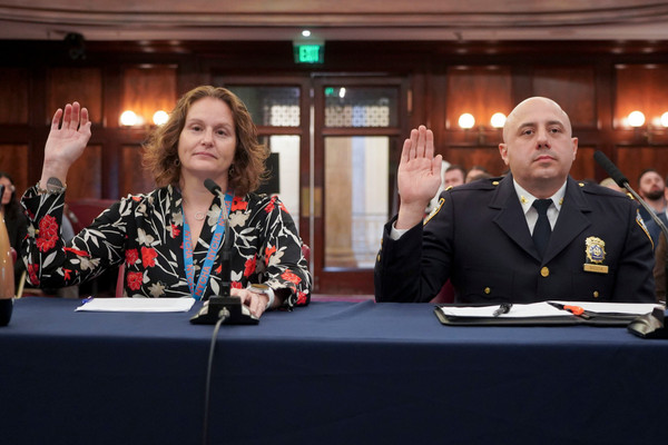 Two city officials at a council hearing