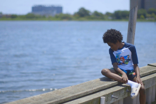 A boy looks out over Jamaica Bay in the Edgemere neighborhood of New York City. The community, which is flanked by the Atlantic Ocean and the bay, is at growing risk of coastal flooding due to sea level rise.