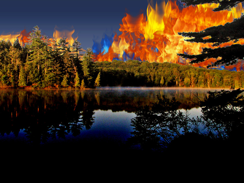 A forest overlooking Long Pond in the St Regis Canoe Area of Adirondack Park with artificial flames superimposed in the sky.