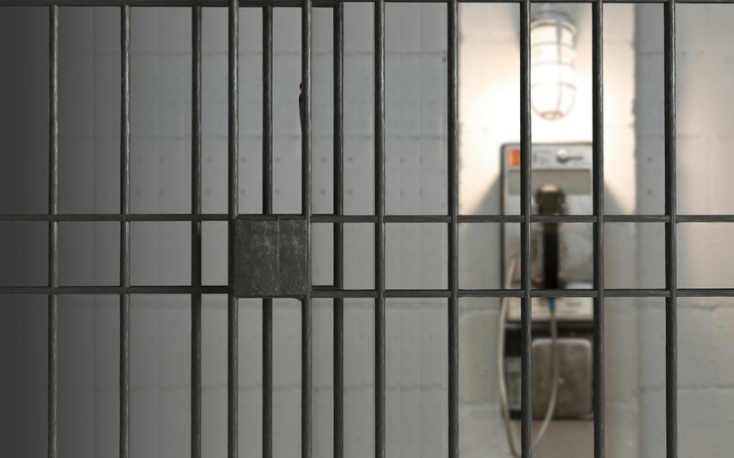 An unreachable phone seen from inside a jail cell.