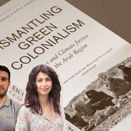 The cover of a book reads, “Dismantling Green Colonialism: Energy and Climate Justice in the Arab Region.” At the bottom of the cover, there’s a picture of women sitting down in a desert, one of them holding a megaphone. In front of the book, there’s a picture of Hamza Hamouchene with his arms crossed and of Manal Shqair smiling.