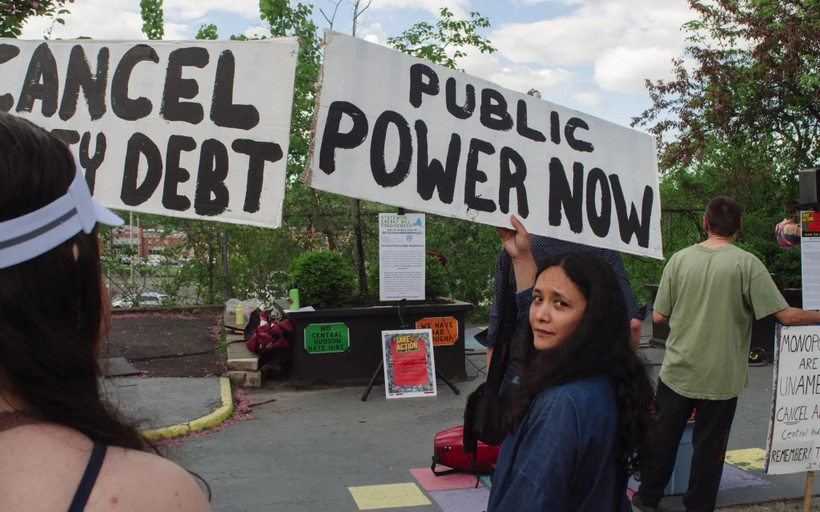 Sarahana Shrestha holding a sign that says "Public Power Now"